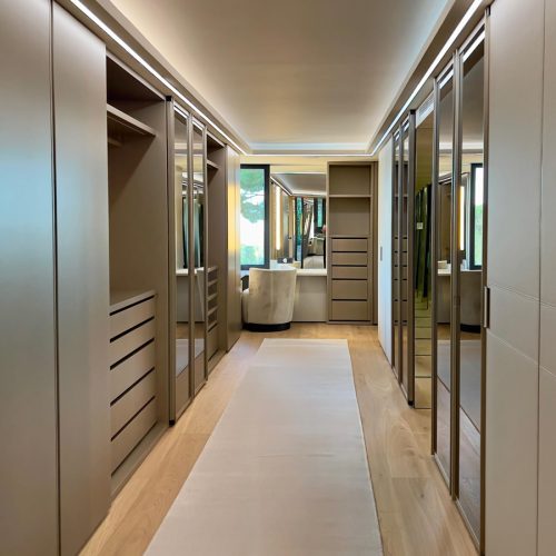 Vestidor de diseño italiano a medida con frentes de espejo, laca y piel en vivienda del Maresme, diseñado por Prada’s Design.